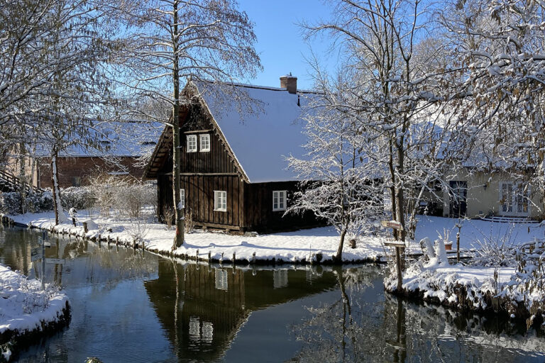 Idyllischer Wasserkanal im Winter, Spreewald-Haus mit Schnee bedeckt.